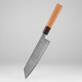 Kirtsuke knife with Damascus steel blade on a dark background, surrounded by ingredients.