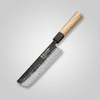 A kitchen knife with a hammered Damascus steel blade and a light wood handle, resting on a wooden cutting board with sliced red cabbage and cilantro.