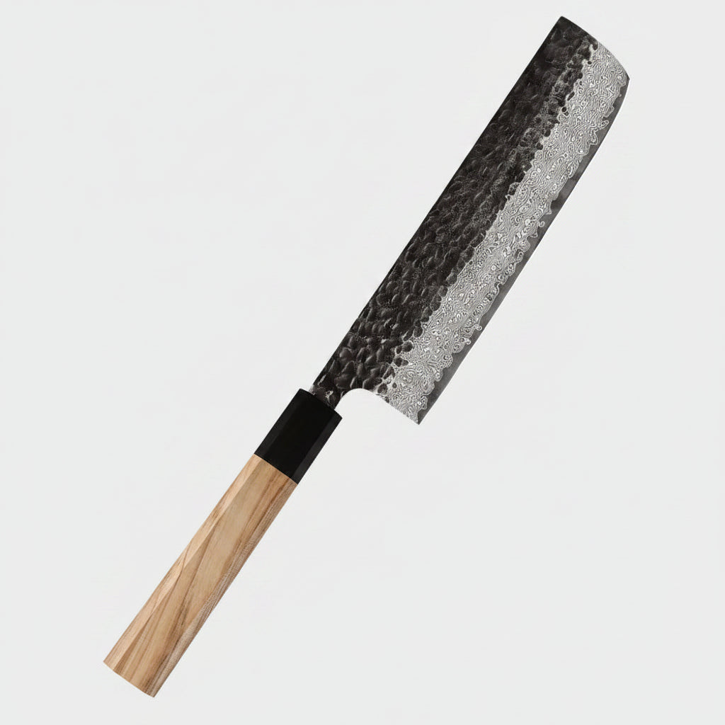 A 67-layer Damascus steel kitchen knife with a hammered blade and an olive wood handle, shown diagonally on a dark blue background with text overlays and red bell pepper props.