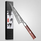 Honesuki knife with Damascus steel blade and wooden handle next to its packaging on a white background.