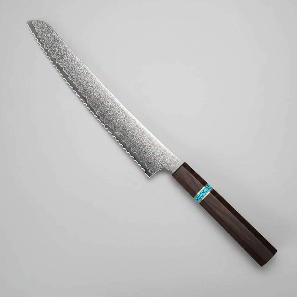 A Japanese-style kitchen knife with a patterned steel blade and dark wooden handle, styled on a dark tabletop with bread, strawberries, lettuce, and a small bowl of sauce.