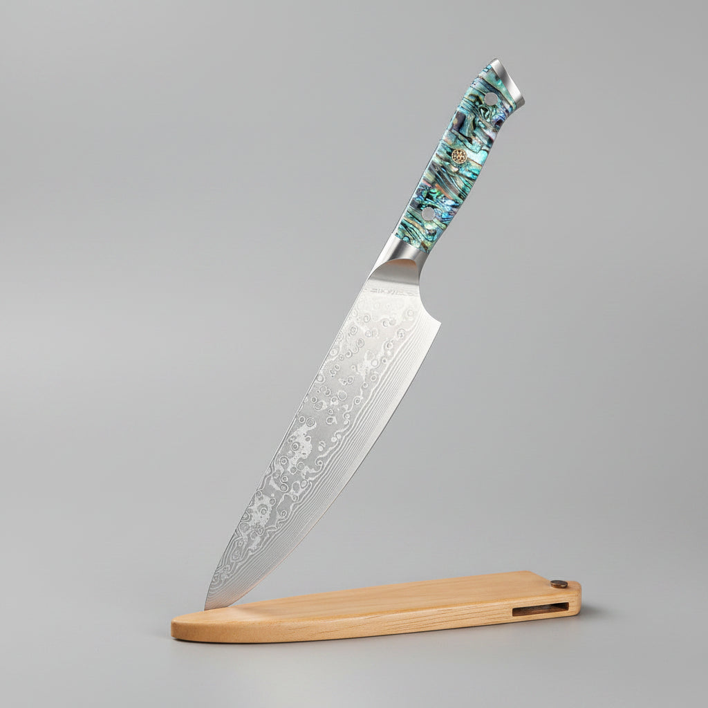 A Damascus steel chef knife with a patterned silver blade and a blue-green marbled handle, shown next to its light brown wooden sheath on a wooden cutting board. Text overlays on the left read '67 Layers Damascus Steel', 'Razor Sharp', and 'Chef Knife'.